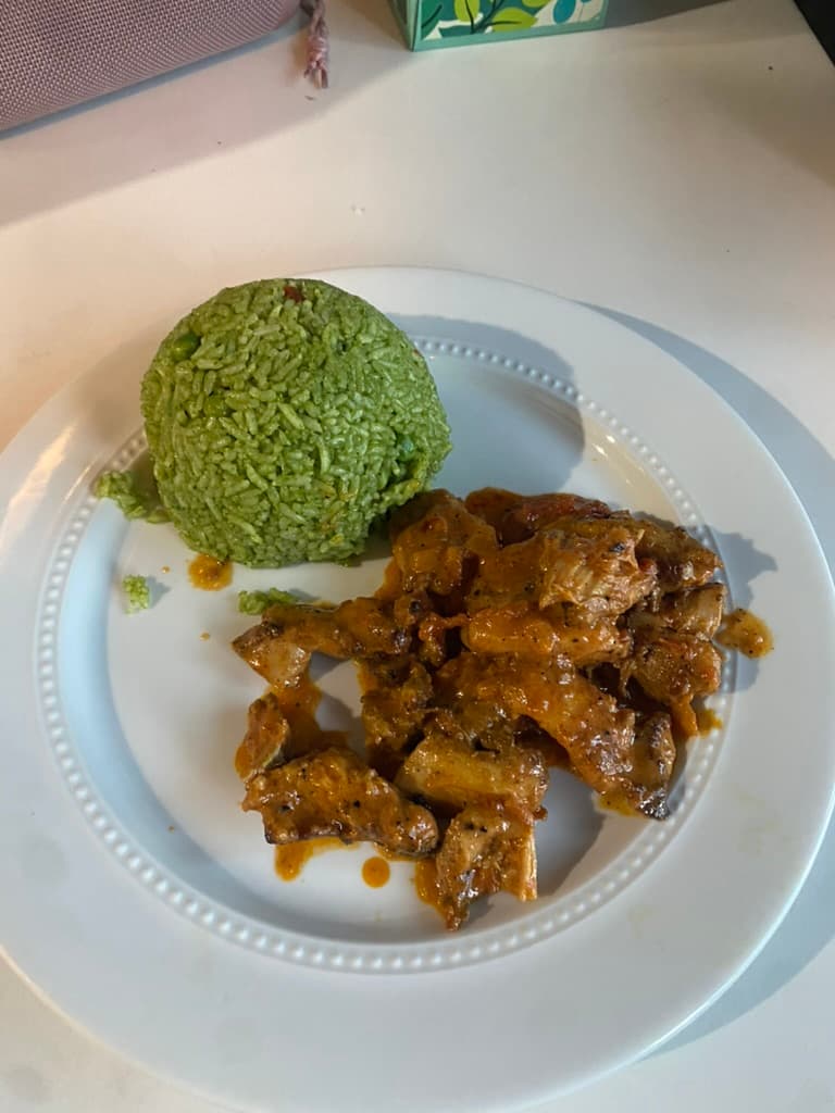 A plated personal chef dish with green rice and sauced steak
