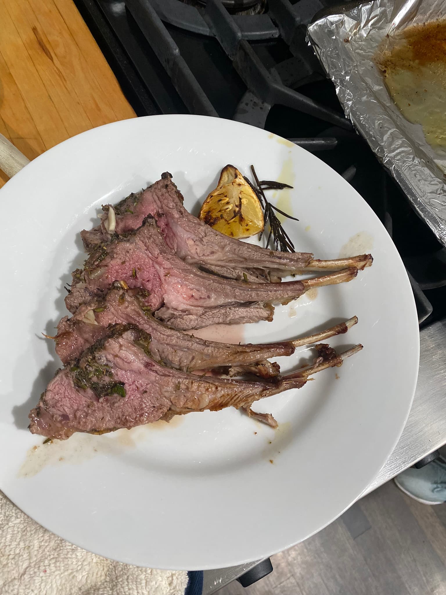 Thyme roasted lamb chops with lemon on a white plate